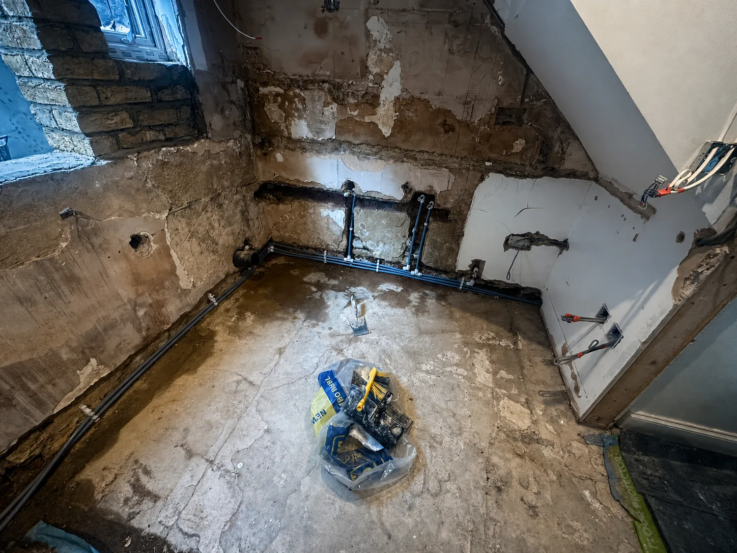 First-fix plumbing routes prepared before the room was rebuilt